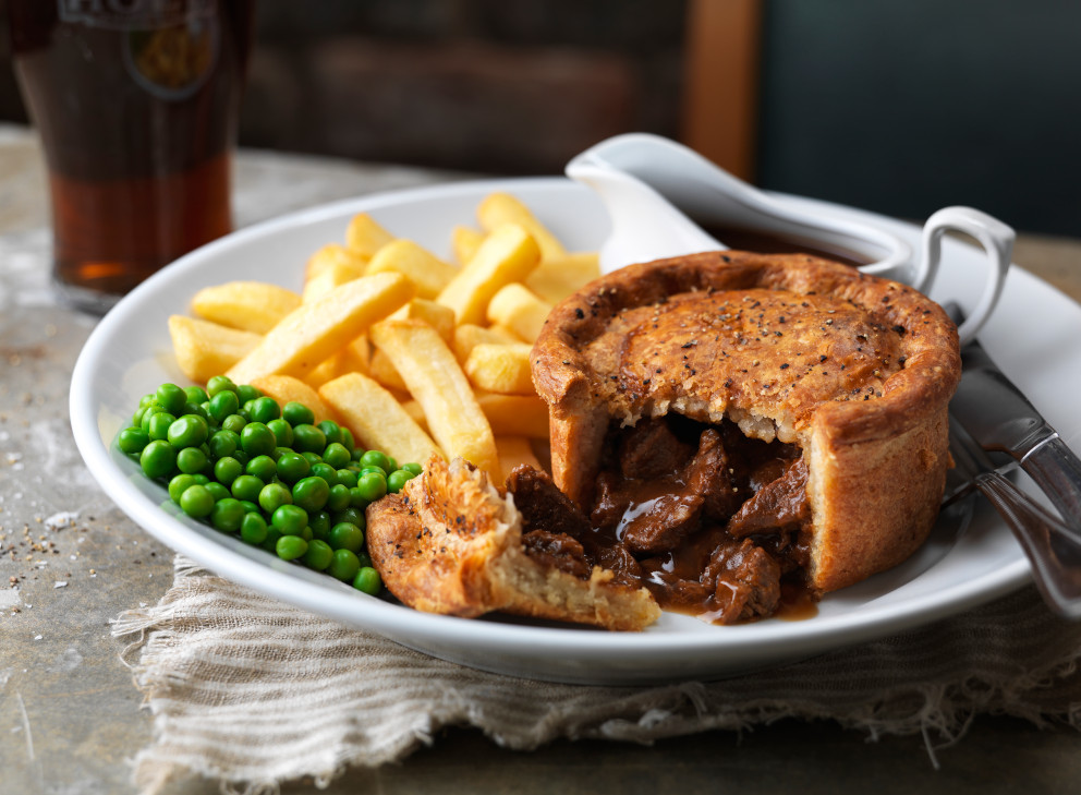 steak pie chips and peas on a plate
