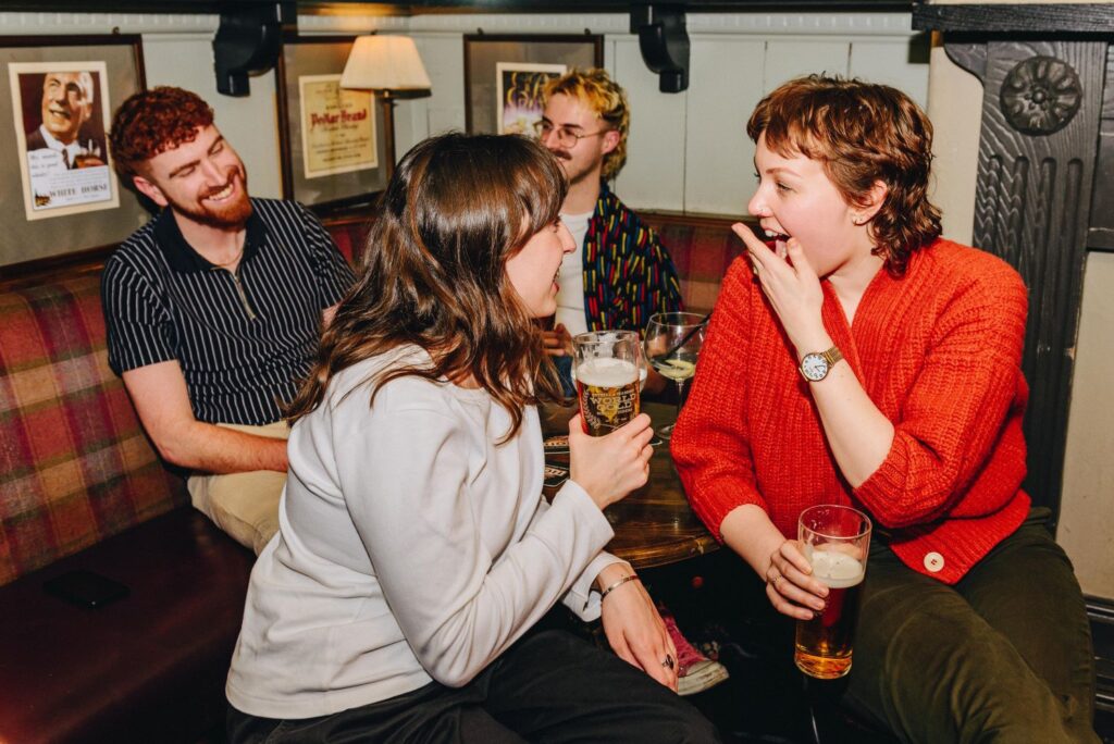 A group of friends drinking round a table