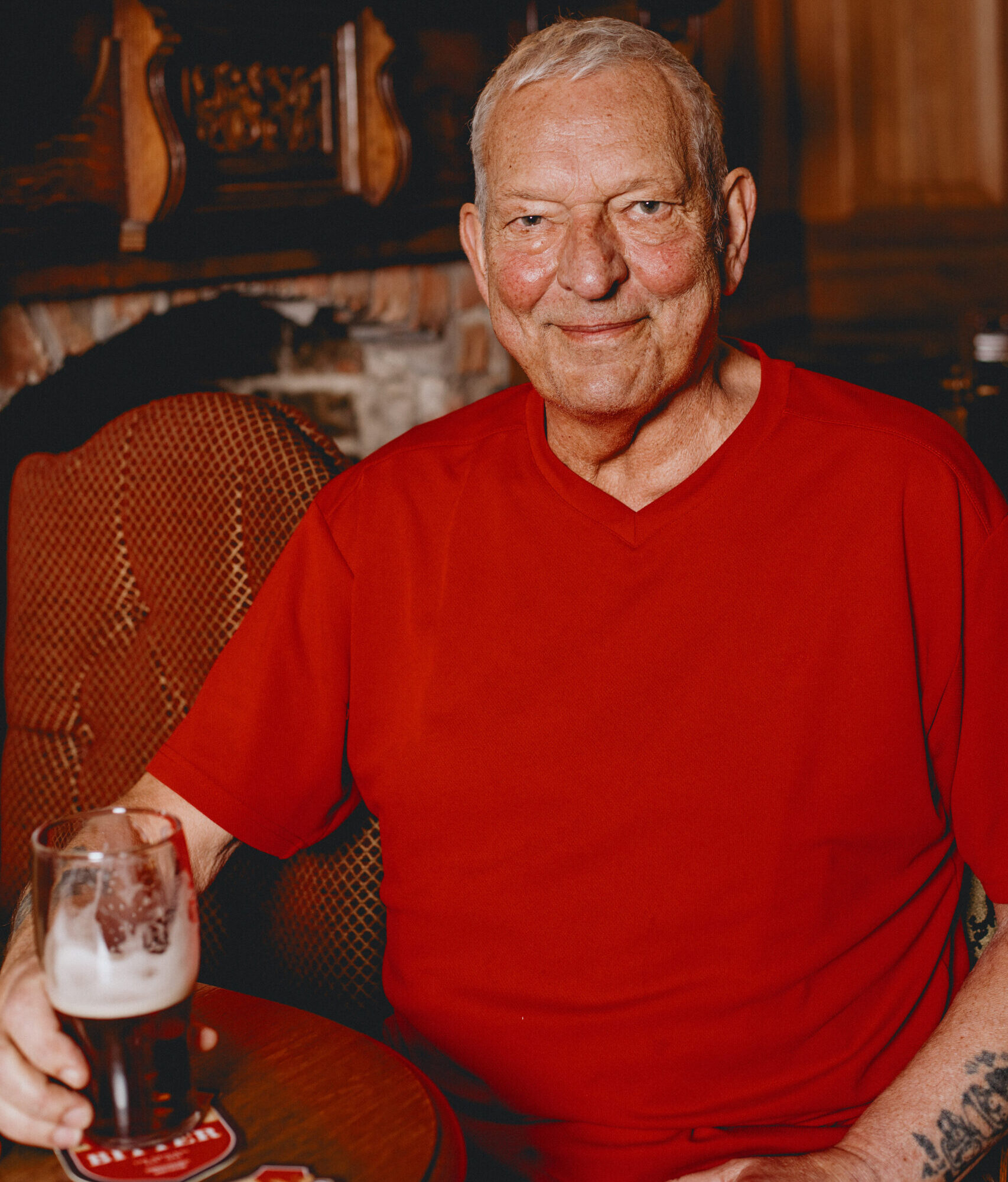 A man sat down holding a pint.