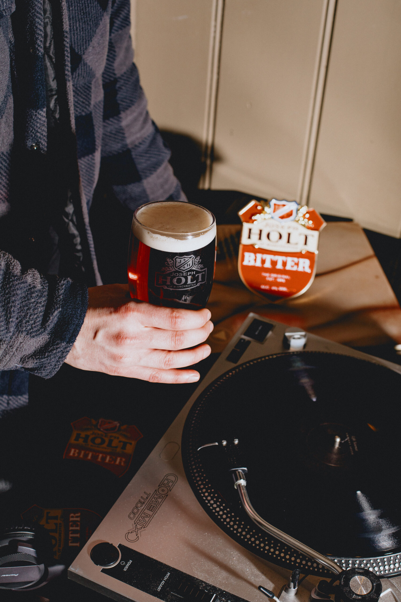 A man holding Bitter next to an LP player.