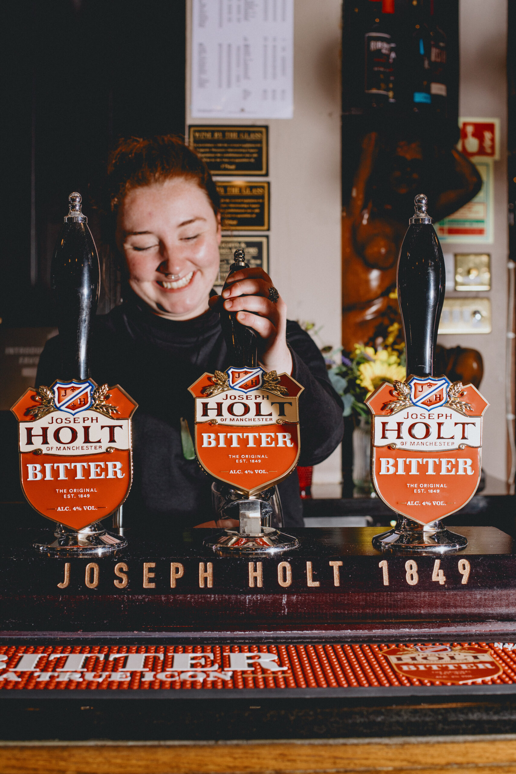 Three Bitter pump clips on a bar.