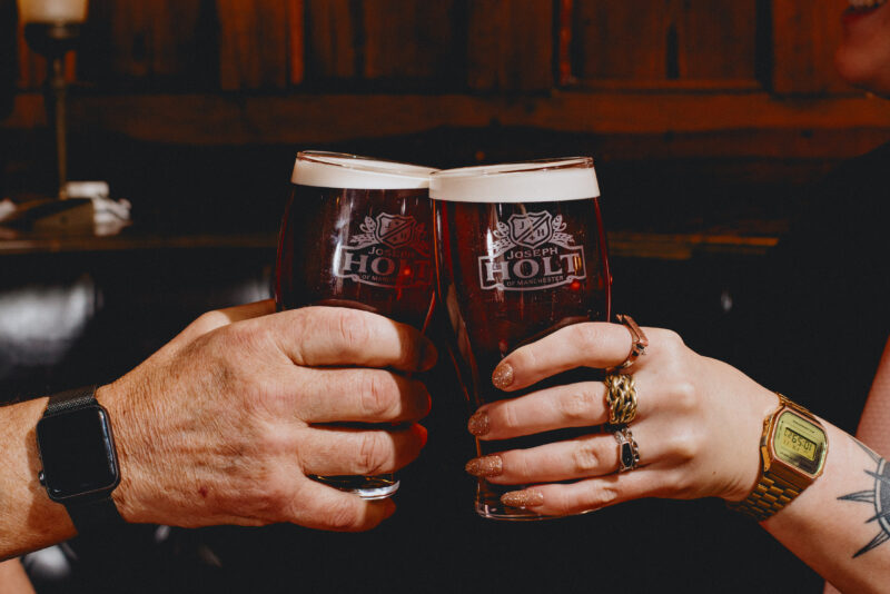 Two people having a cheers with pints of Bitter.
