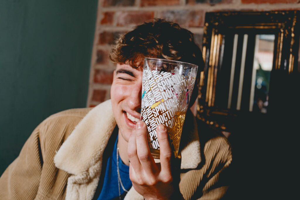 A young man looking through a pint